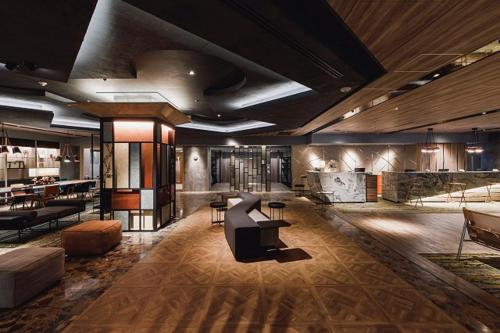a lobby with couches and tables in a building at Shin Osaka Esaka Tokyu REI Hotel in Suita