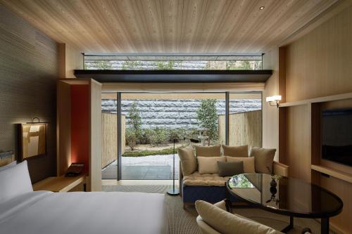 Zimmer mit einem Bett, einem Sofa und einem Glastisch in der Unterkunft Park Hyatt Kyoto in Kyoto