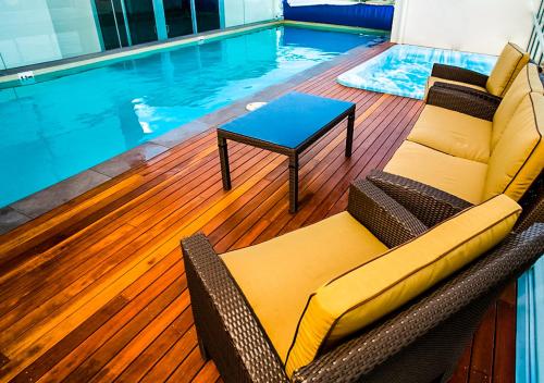 a pool with a couch and a table next to a swimming pool at Toowoomba Central Plaza Apartment Hotel Official in Toowoomba