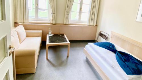 a room with a bed and a couch and a table at Hotel Alte Post in Mindelheim