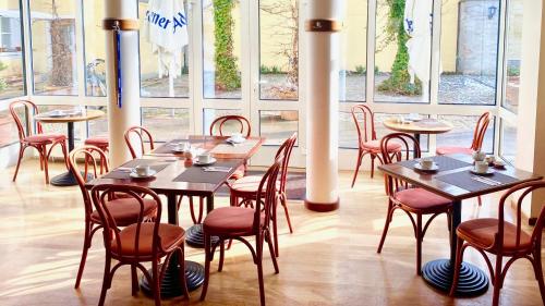 a dining room with tables and chairs and windows at Hotel Alte Post in Mindelheim