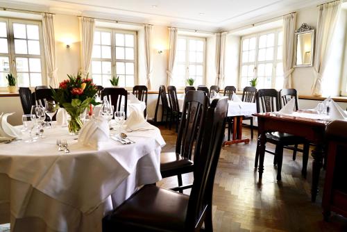 a dining room with tables and chairs with white table cloth at Hotel Alte Post in Mindelheim