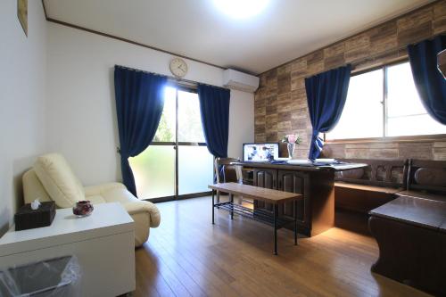 a living room with a desk and a table at Tiz wan 洲本 in Sumoto