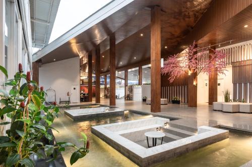 a lobby with a pool with two water tables at Kontena Hotel in Batu