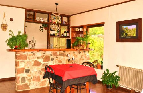 a kitchen with a table with a red table cloth at Hosteria El Ceibo in La Cumbrecita