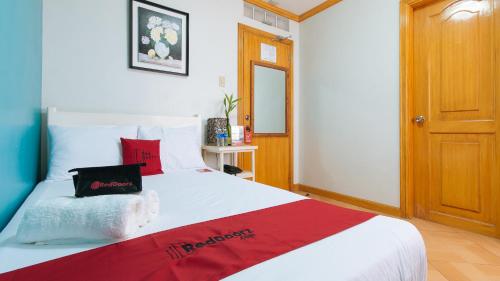 a bedroom with a large white bed with red pillows at RedDoorz @ Arimbay Legazpi City in Legazpi