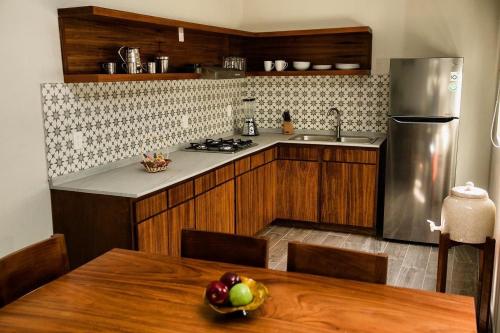 a kitchen with a table and a refrigerator and a sink at Casa MAYAHUEL x Santiago de Tequila in Tequila