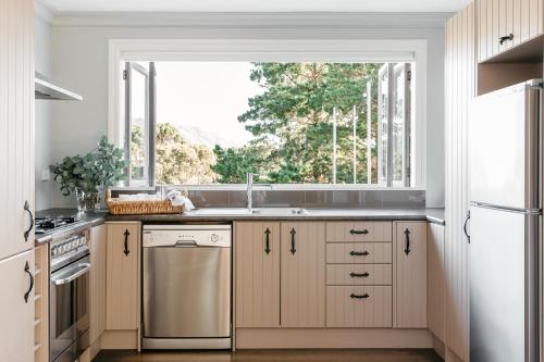 uma cozinha com um lavatório e uma janela em Cottage 103 em Waikanae