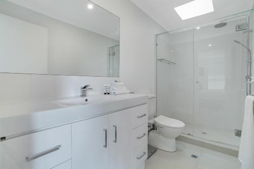 a white bathroom with a toilet and a shower at Privacy by the river, Noosaville in Noosaville