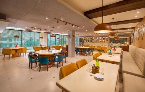 a restaurant with tables and chairs and windows at Bloom Boutique l Ranjit Avenue in Amritsar