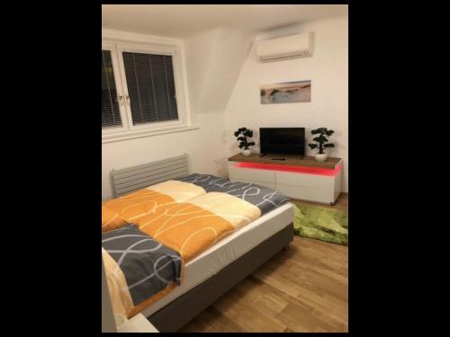 a bedroom with a bed and a flat screen tv at Walzhofer Apartement in Vienna