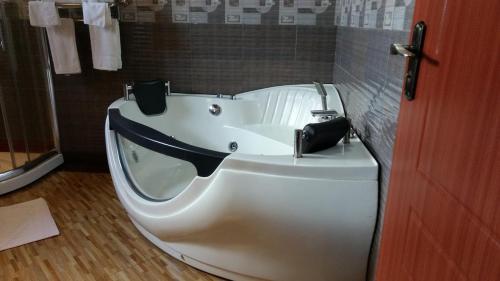 een wit bad in een badkamer met een douche bij Milimani Beach Resort in Kisumu