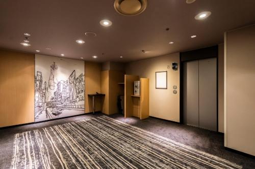 an empty room with a large painting on the wall at Shin Osaka Esaka Tokyu REI Hotel in Suita