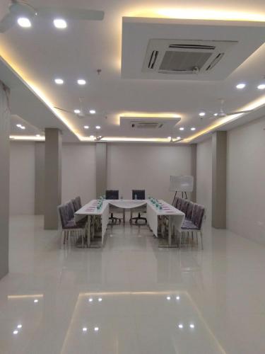 a meeting room with tables and chairs and a ceiling at Hotel Sopan Heights in New Delhi
