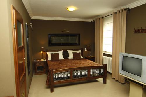 1 dormitorio con 1 cama y TV en Art Hotel Neckar, en Neckargemünd