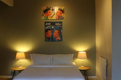 a bedroom with a bed with two lamps and a poster on the wall at Lucky Bean Guesthouse in Johannesburg
