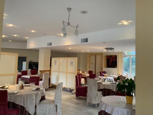 d'une salle à manger avec des tables et des chaises blanches et un porte-table. dans l'établissement L’air du temps, à Beauzac