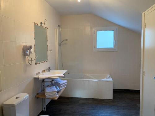 a bathroom with a sink and a tub and a mirror at L’air du temps in Beauzac