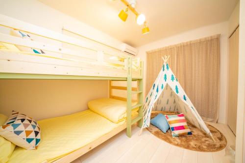 a bedroom with two bunk beds and a teepee at Tachibana in Tokyo