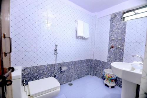 uma casa de banho com uma banheira, um WC e um lavatório. em Hotel Rashmi em Agra