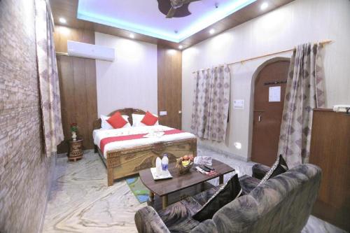 a bedroom with a bed and a couch and a table at Hotel Rashmi in Agra