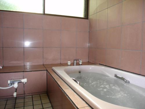 a bath tub in a bathroom with pink tiles at Cottage All Resort Service / Vacation STAY 8401 in Inawashiro
