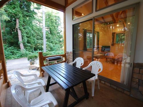 Cottage All Resort Service / Vacation STAY 8401 في Inawashiro: طاولة خشبية وكراسي بيضاء على شرفة