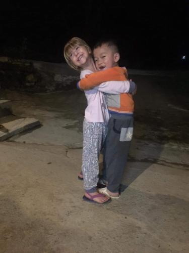 two young boys are hugging each other at Tày Cốc Pảng Homestay in Làng Cac