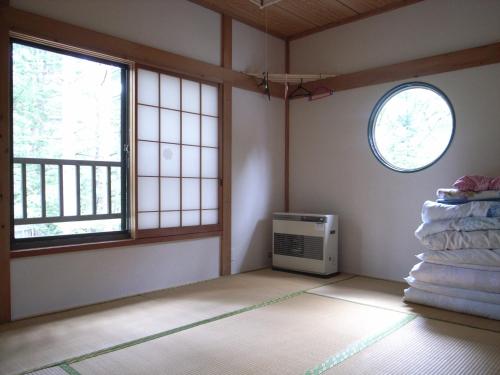 een lege kamer met verwarming en twee ramen bij Cottage All Resort Service / Vacation STAY 8406 in Inawashiro