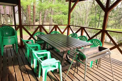 een houten tafel en stoelen op een terras bij Cottage All Resort Service / Vacation STAY 8406 in Inawashiro