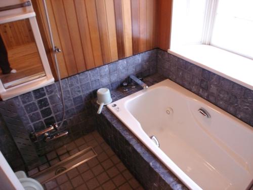 Cottage All Resort Service / Vacation STAY 8416 في Inawashiro: حوض استحمام في الحمام مع نافذة