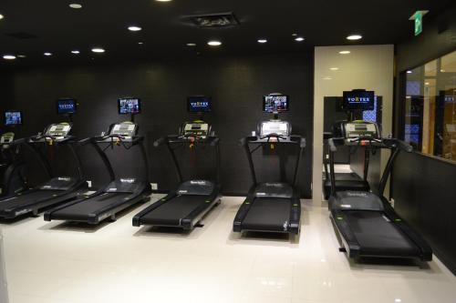 a row of treadles in a gym with television screens at ANA Crowne Plaza Matsuyama by IHG in Matsuyama