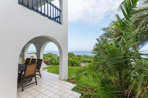 een patio met uitzicht op de oceaan vanuit een huis bij Santorini - Pyrgos 15 in Ballito