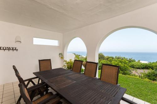 een tafel en stoelen op een balkon met uitzicht op de oceaan bij Santorini - Pyrgos 15 in Ballito