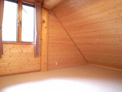 ein leeres Zimmer mit Holzwänden und Fenstern in der Unterkunft Cottage All Resort Service / Vacation STAY 8420 in Inawashiro