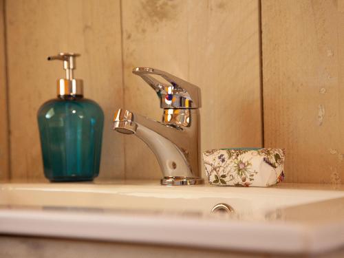 a bathroom sink with a faucet and a bottle of soap at Can Elisa Safari Tent in Tárbena