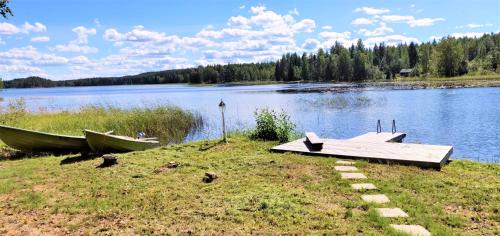 a dock and two boats on the shore of a lake at Villa Aurinkoranta in Enonkoski