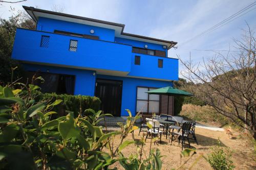 a blue house with tables and chairs in front of it at Tiz wan 洲本 in Sumoto