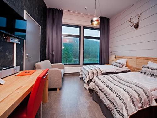 a hotel room with two beds and a desk at Holiday Village Valle in Utsjoki