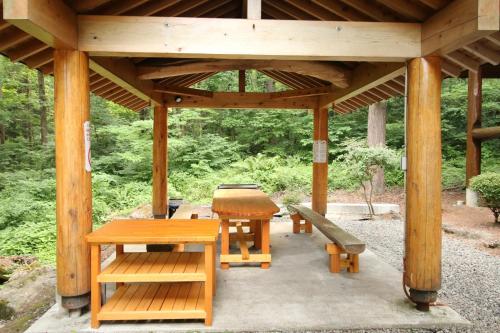 einem Holzpavillon mit einem Picknicktisch und einer Bank in der Unterkunft Cottage All Resort Service / Vacation STAY 8422 in Inawashiro