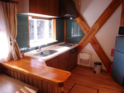 una pequeña cocina con fregadero y ventana en Cottage All Resort Service / Vacation STAY 8416 en Inawashiro