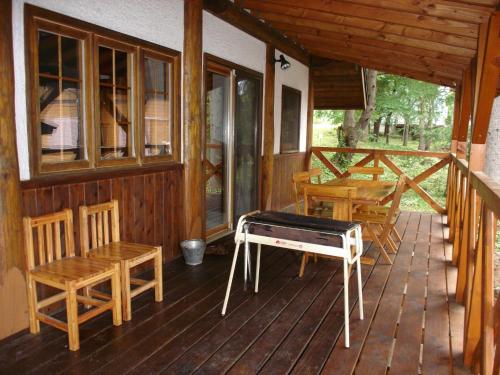 Cottage All Resort Service / Vacation STAY 8416 في Inawashiro: شرفة كابينة مع طاولة وكراسي