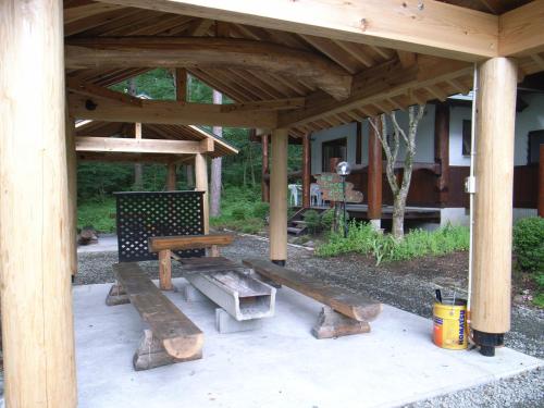 einem Picknicktisch aus Holz und einer Bank unter einem Pavillon in der Unterkunft Cottage All Resort Service / Vacation STAY 8420 in Inawashiro