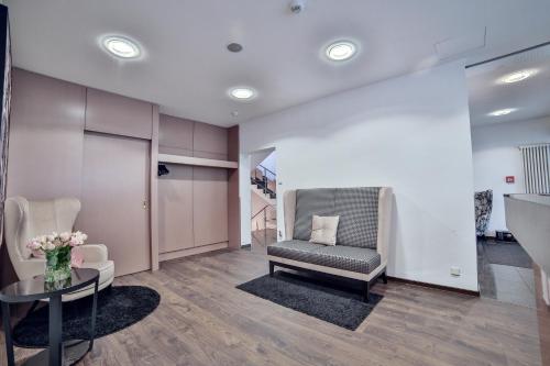 a waiting room with a chair and a table at City Partner Hotel Berliner Hof in Karlsruhe