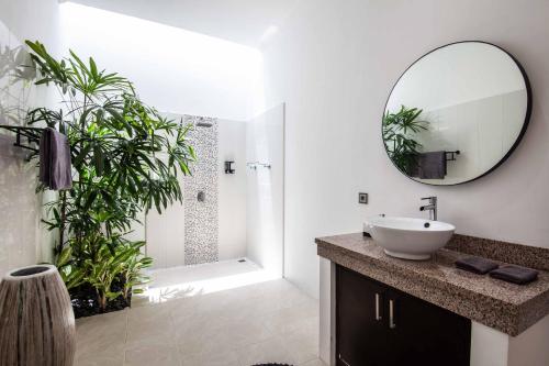 ein Badezimmer mit Waschbecken, Dusche und Spiegel in der Unterkunft Villa Voyage 5 in Seminyak