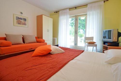 um quarto com uma cama grande e um cobertor laranja em Apartment Rojnic - 3 bedrooms apartment em Pula