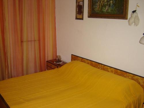 - une chambre avec un lit et une couverture jaune dans l'établissement Apartments Grgorinić - Ground Floor, à Pula