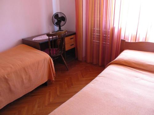 1 dormitorio con 2 camas y escritorio con silla en Apartments Grgorinić 3 bedrooms, en Pula