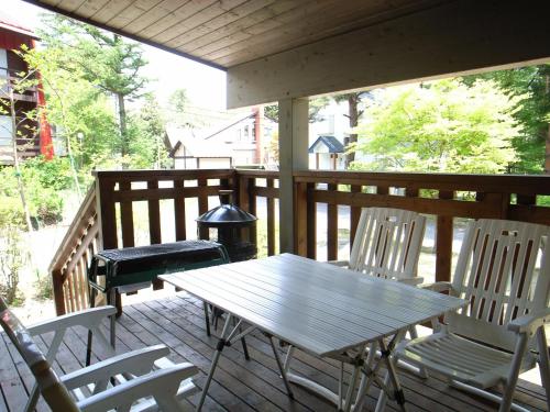 einen Holztisch und Stühle auf einer Veranda in der Unterkunft Cottage All Resort Service / Vacation STAY 8441 in Inawashiro