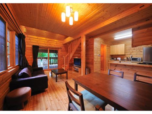 ein Wohnzimmer mit einem Tisch und einer Küche in der Unterkunft Cottage All Resort Service / Vacation STAY 8441 in Inawashiro